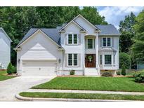 Charming two-story traditional home with a well-manicured lawn, attached garage, and welcoming front entrance at 8841 Deerland Grove Dr, Raleigh, NC 27615