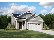Charming home with gray siding, a two-car garage, manicured lawn, and a welcoming entryway at 115 Vulcan St, Garner, NC 27529