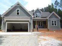 Charming two-story home features gray siding, attached garage, and inviting front porch details at 1155 Shonele Ln, Stem, NC 27581
