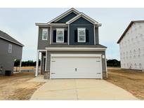 Charming two-story home featuring a two-car garage and neutral-tone siding, ready for its new owners at 120 Bruce Dr, Dunn, NC 28334