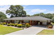 Charming brick home with a well-manicured front yard and attached carport at 12082 Nc 42, Fuquay Varina, NC 27526