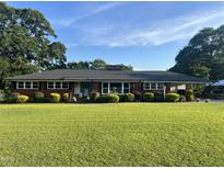 Well-maintained single-story brick home featuring a lush front yard with manicured landscaping at 12082 Nc 42, Fuquay Varina, NC 27526