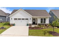 Charming single-story home featuring a white exterior, attached garage, and professionally landscaped front yard at 1319 Richfield Oaks Dr, Fuquay Varina, NC 27526