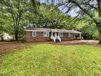 Charming brick home featuring a well-maintained lawn and surrounded by mature trees at 1508 Hodge Rd, Knightdale, NC 27545