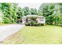 Charming home with a well-manicured lawn, complemented by a convenient carport and lush trees at 1605 Goldsboro Ave, Sanford, NC 27330