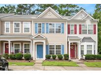Charming townhomes featuring colorful shutters, well-manicured lawns, and inviting front doors at 1642 Holly Grove Way, Durham, NC 27713