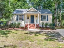 Charming home featuring a welcoming front porch, tasteful landscaping, and classic architectural details at 1825 Watkins St, Raleigh, NC 27604