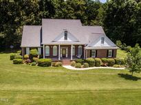 Charming brick home featuring a welcoming front porch and beautifully landscaped yard at 2819 Russell Mcpherson Rd, Burlington, NC 27215