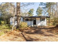 Charming single-story home with a covered porch and well-maintained landscaping, surrounded by mature trees at 3013 Avery St, Raleigh, NC 27610