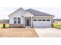 Charming home with stone accents, neutral siding, well-manicured yard, and a two-car garage at 324 Longleaf Glen Court, Zebulon, NC 27597