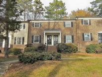 Brick townhouse with black shutters and landscaping at 3738 Jamestown Cir, Raleigh, NC 27609