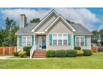 Charming single story home featuring light tan siding, a chimney, and a well maintained front yard at 402 Hearthstone Dr, Nashville, NC 27856