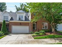 Charming brick home featuring an attached two-car garage and professionally landscaped front yard at 4211 Norman Ridge Ln, Raleigh, NC 27613