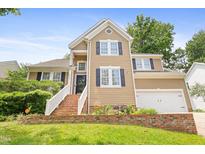Inviting two-story home with brick-lined steps and manicured landscaping, plus a garage at 613 Penncross Dr, Raleigh, NC 27610
