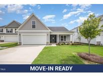Charming single-Gathering home with a gray exterior, attached garage, and well-manicured lawn at 66 W Emily Gardens Dr, Selma, NC 27576