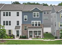 Charming townhome with a combination of siding and brick, covered porch, and well-maintained lawn at 6928 Leesville Rd, Raleigh, NC 27613