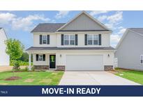 Charming two-story home features white siding, black shutters, and a well-manicured lawn at 74 W Emily Gardens Dr, Selma, NC 27576