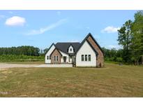 Stunning two-story home featuring white siding, stone accents, black trim and a well-manicured front yard at 7620 Sam Hall Rd, Oxford, NC 27565