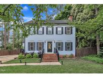 Charming two-story home with a well-maintained lawn, brick stairs, and a classic front door at 7917 Featherstone Dr, Raleigh, NC 27615