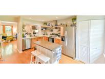 Bright kitchen featuring stainless steel appliances, light wood cabinets, island with seating and open shelving at 875 Martin Luther King Jr Blvd # 7, Chapel Hill, NC 27514