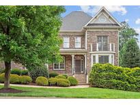 Charming brick two-story home boasts a landscaped front yard and inviting entrance at 10012 San Remo Pl, Wake Forest, NC 27587