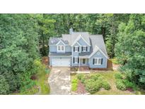 Charming two-story home featuring a lush, landscaped front yard and attached two-car garage at 107 E Seve Ct, Morrisville, NC 27560