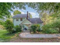Charming two-story home with light green siding, brick chimney, and well-manicured front yard at 108 High St, Carrboro, NC 27510