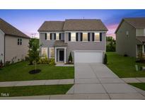 Charming two-story home with gray siding, black shutters, and well-manicured front yard at 120 Misty Grove Trail Trl, Franklinton, NC 27525