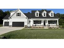 Charming new construction home showcasing a two-car garage, inviting porch, and manicured lawn at 129 Hot Springs Way, Benson, NC 27504