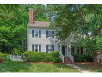 Charming two-story house surrounded by lush greenery, featuring blue shutters and a brick chimney at 1701 Berwickshire Cir, Raleigh, NC 27615