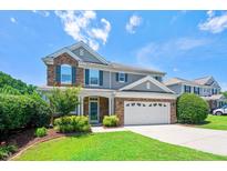 Charming two-story home with a stone and siding exterior, manicured lawn, and attached two-car garage at 1831 Devonridge Dr, Fuquay Varina, NC 27526