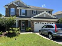 Charming two-story home with stone accents, attached garage, well-kept lawn, and car parked in the driveway at 1831 Devonridge Dr, Fuquay Varina, NC 27526