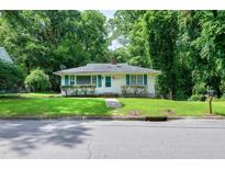 Charming one-story home featuring a cozy front yard and light-colored exterior with green shutters at 1907 Bivins St, Durham, NC 27707