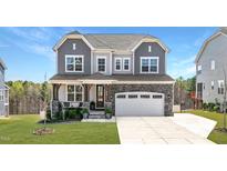 Charming two-story home featuring a stone-accented facade, gray siding, and an attached two-car garage at 199 High Woods Rdg, Chapel Hill, NC 27517
