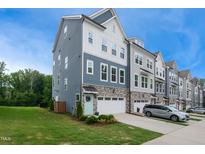 Beautifully designed townhome with blue and gray siding, stone accents, and a welcoming front lawn at 2055 Eva Pearl Dr, Apex, NC 27502