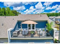 This rooftop deck offers comfortable seating and a stylish umbrella, perfect for outdoor relaxation at 2055 Eva Pearl Dr, Apex, NC 27502