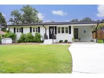 Charming one-story home with well-manicured lawn, white brick, black shutters, and covered front entrance at 2320 Marks Creek Rd, Knightdale, NC 27545