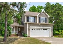 Charming two-story home featuring a large front yard, a two-car garage, and mature trees at 2575 Primrose Ln, Creedmoor, NC 27522