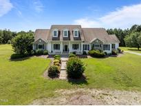 Charming home featuring stone accents, dormer windows, rocking chair front porch and lush landscaping on a well manicured lawn at 2637 S Nc 87, Graham, NC 27253