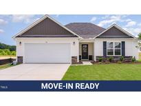 Charming single-story home featuring a two-car garage, stone accents, and a well-manicured lawn at 30 Chloe Ct, Selma, NC 27576