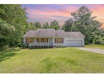 Charming single-story home with a well-manicured lawn and attached garage at 3336 Piney Grove Wilbon Rd, Fuquay Varina, NC 27526