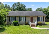 Charming one-story home featuring a well-maintained lawn, complemented by dark shutters against light siding and a brick walkway at 3624 Meadow Creek Ln, Raleigh, NC 27616