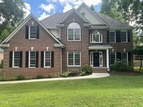 Charming brick two-story home with black shutters and manicured front lawn at 3811 Cottonwood Dr, Durham, NC 27705