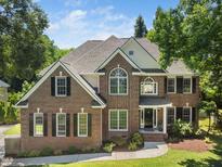 Charming two-story brick home with well-manicured lawn and mature trees providing a private setting at 3811 Cottonwood Dr, Durham, NC 27705