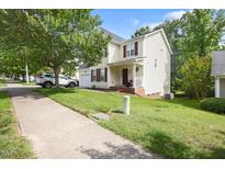 Charming two-story home with a well-manicured lawn, front-facing garage and a cozy front porch at 401 Holly Thorn Trce, Holly Springs, NC 27540