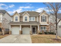 Beautiful two-story home featuring a two-car garage, stone accents, and a well-manicured front yard at 413 Westfalen Dr, Cary, NC 27519