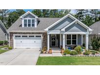 Charming home with brick and siding facade, two-car garage, and landscaped front yard offers delightful curb appeal at 440 Bramble Ln, Clayton, NC 27527