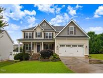 Charming two-story home with a manicured lawn, attached garage, and inviting front porch at 52 Summit Overlook Dr, Clayton, NC 27527