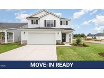 Charming two-story home featuring a two-car garage, well-maintained lawn, and classic black-and-white color scheme at 58 W Emily Gardens Dr, Selma, NC 27576