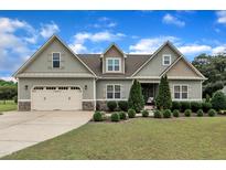 Charming two-story home featuring a manicured lawn, an attached two-car garage, and lovely landscaping at 71 Smithsanders Ct, Smithfield, NC 27577
